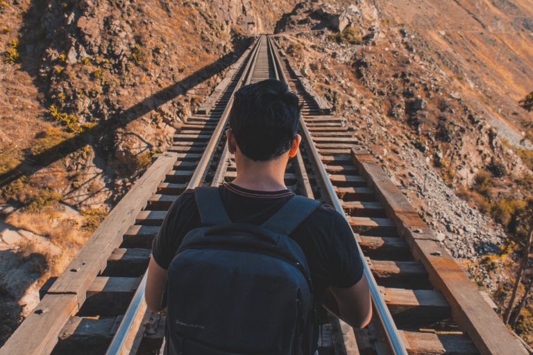 Un chico frente a unos rieles de tren simboliza la ruta hacia la modernización de la gestión pública